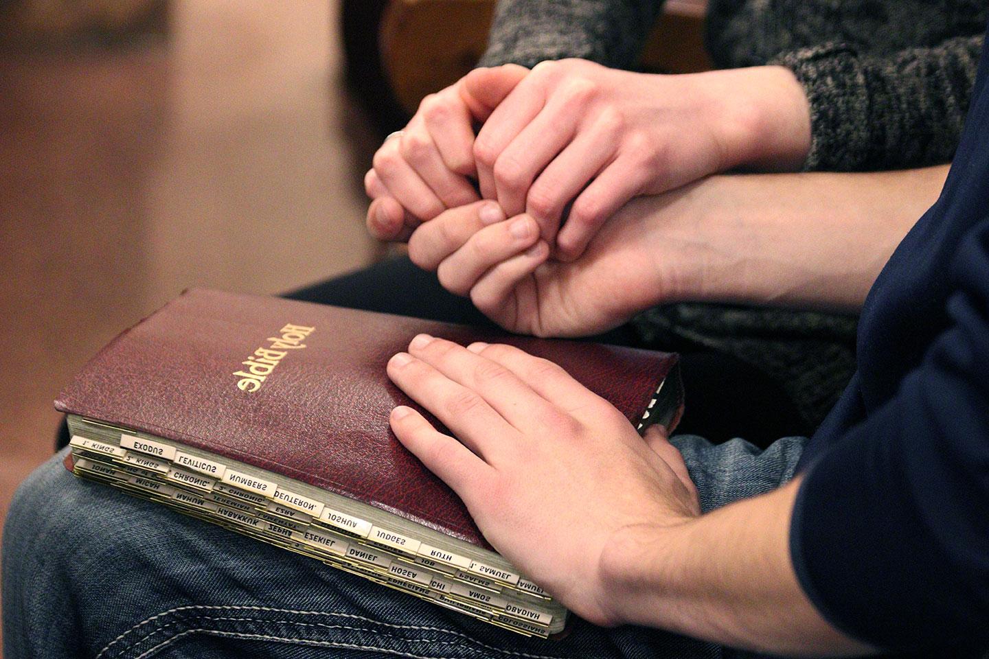 praying with hand on bible