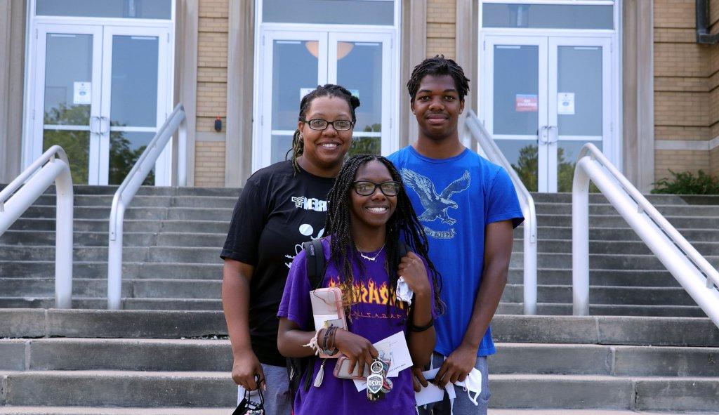 Family stands together in front of Le Fer Hall